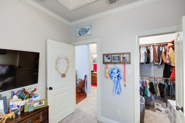 bedroom featuring visible vents, ornamental molding, a closet, and light colored carpet