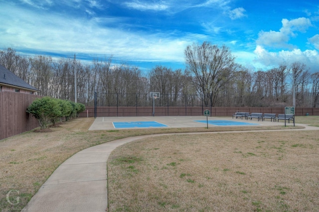 view of swimming pool with community basketball court, fence, and a lawn