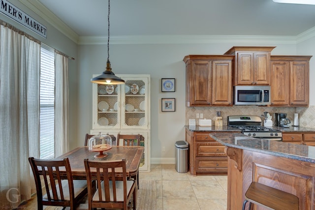 kitchen with stainless steel appliances, ornamental molding, and decorative backsplash