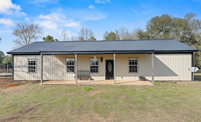 exterior space featuring metal roof, a yard, a trampoline, and a patio area