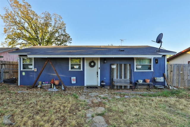 rear view of house featuring fence