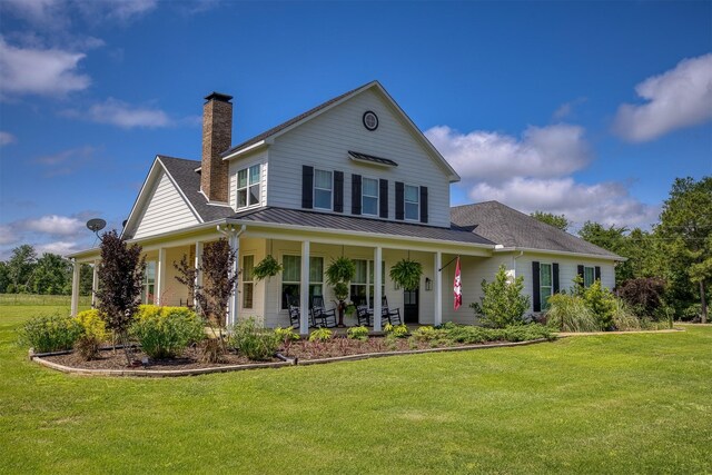 1188 An County Road 103, Elkhart, TX 75839 - view of front of property featuring a porch, a front lawn, a chimney, and roof with shingles