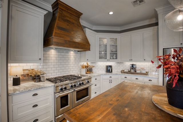 1188 An County Road 103, Elkhart, TX 75839 - kitchen with stainless steel appliances, wood counters, custom range hood, white cabinets, and backsplash
