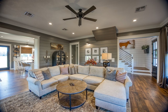 1188 An County Road 103, Elkhart, TX 75839 - living room featuring crown molding, wooden walls, wood finished floors, stairs, and ceiling fan