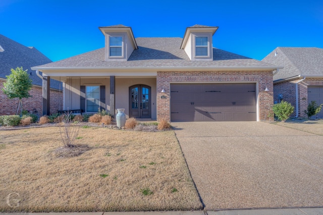 view of front of home with a garage, concrete driveway, brick siding, and a shingled roof