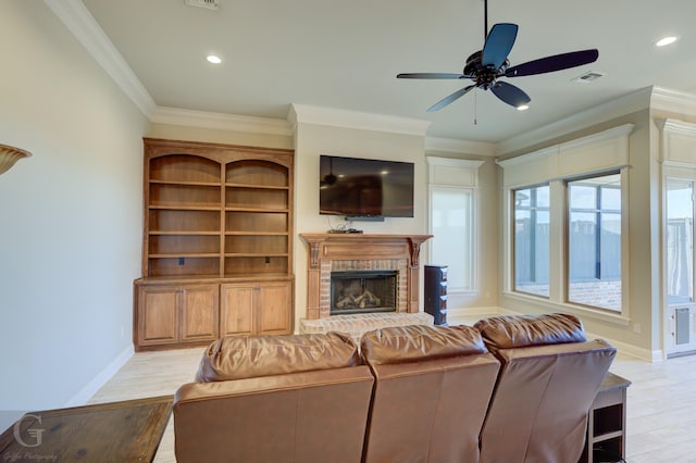 living room featuring baseboards, visible vents, ornamental molding, light wood-type flooring, and a brick fireplace