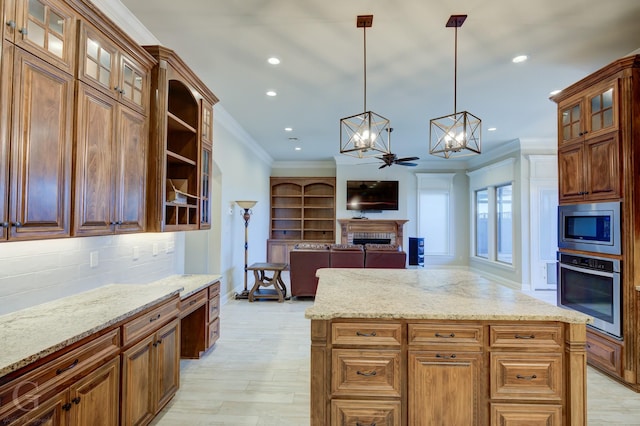 kitchen with light stone counters, decorative light fixtures, stainless steel appliances, glass insert cabinets, and crown molding