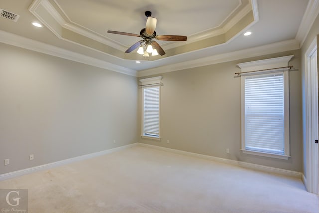 empty room featuring visible vents, a raised ceiling, and light colored carpet