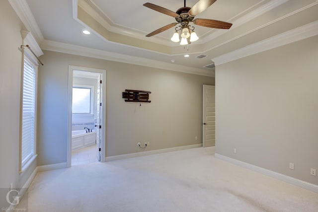 unfurnished bedroom featuring light carpet, baseboards, a tray ceiling, crown molding, and recessed lighting