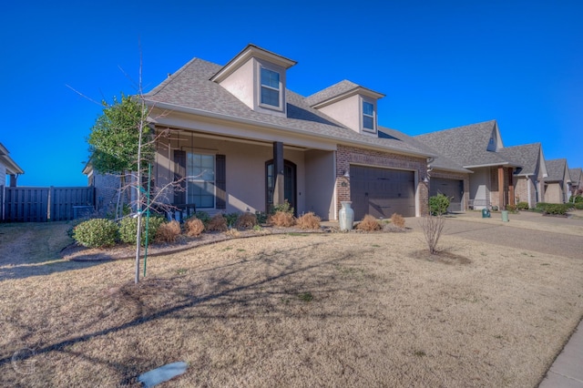 view of front of property with a garage, stucco siding, roof with shingles, fence, and brick siding