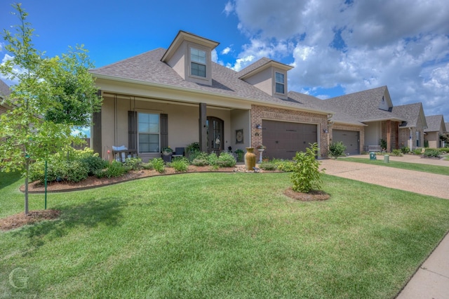 view of front of house with a garage, brick siding, a front lawn, a porch, and stucco siding