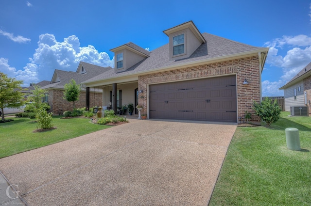 view of front of home featuring a front yard, brick siding, an attached garage, and central AC unit