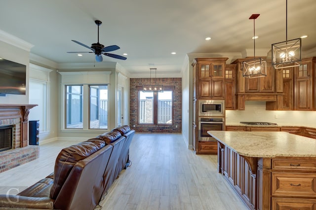 kitchen featuring decorative light fixtures, a kitchen island, open floor plan, appliances with stainless steel finishes, and glass insert cabinets