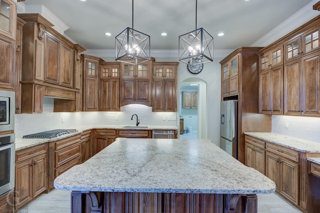 kitchen with glass insert cabinets, arched walkways, a kitchen island, and appliances with stainless steel finishes