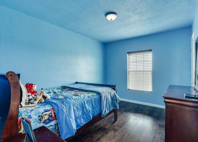 bedroom with dark wood-style floors, baseboards, and a textured ceiling