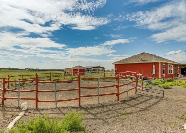 view of yard featuring an outdoor structure, an exterior structure, and a rural view