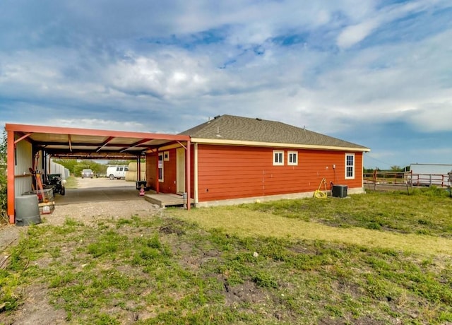 view of side of home featuring a carport, central AC, and fence