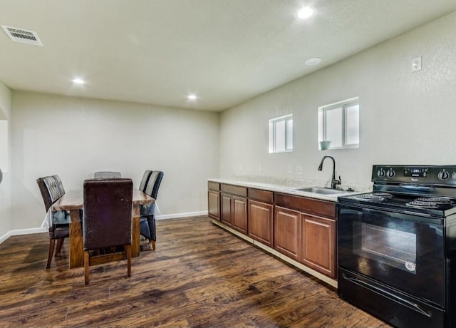 kitchen featuring baseboards, dark wood-style floors, black / electric stove, light countertops, and a sink