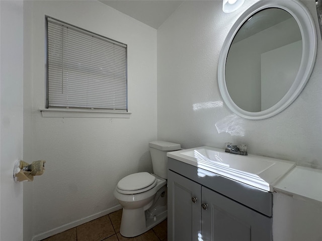 bathroom featuring toilet, tile patterned floors, baseboards, and vanity