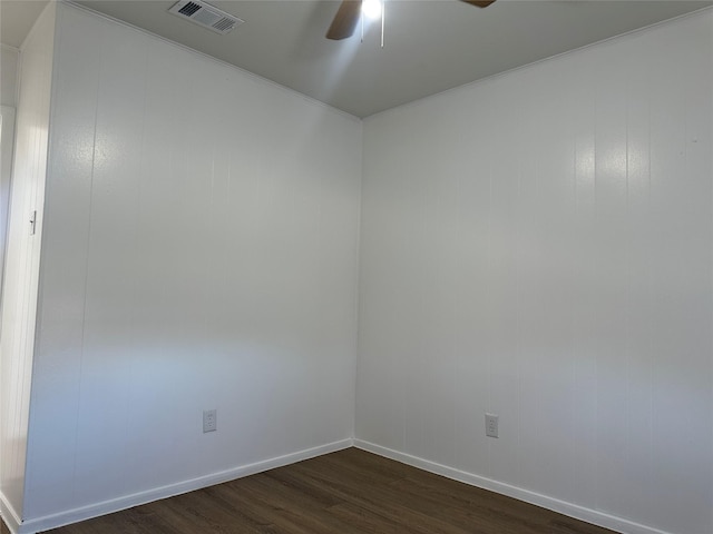 spare room featuring baseboards, ceiling fan, visible vents, and dark wood-style flooring