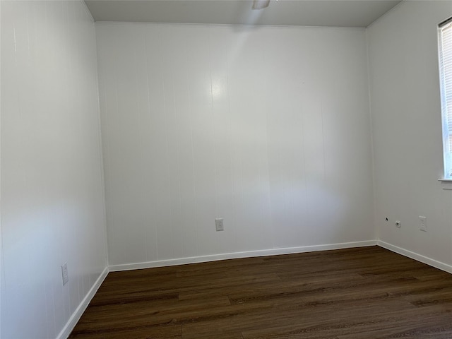 unfurnished room with dark wood-style floors and baseboards