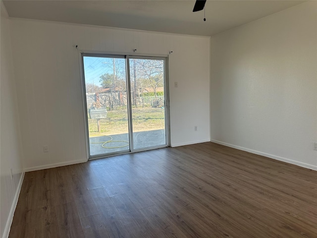 spare room with ceiling fan, baseboards, and dark wood finished floors