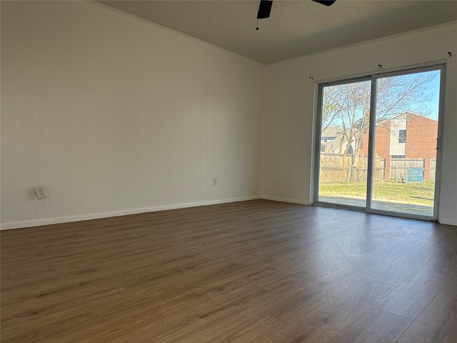 empty room featuring dark wood-type flooring, ceiling fan, and baseboards