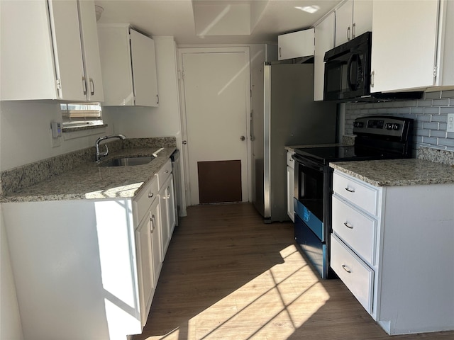 kitchen with black appliances, white cabinetry, and a sink