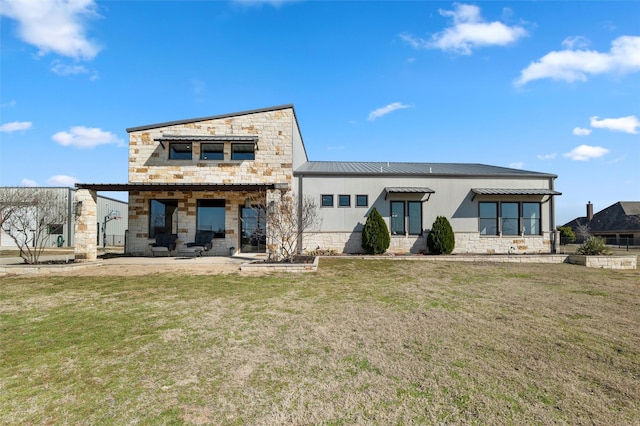 back of property featuring stone siding, a yard, and a patio