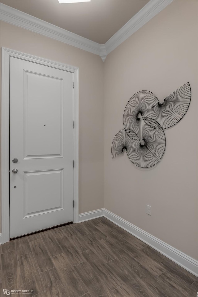 foyer entrance featuring dark wood-style floors, crown molding, and baseboards