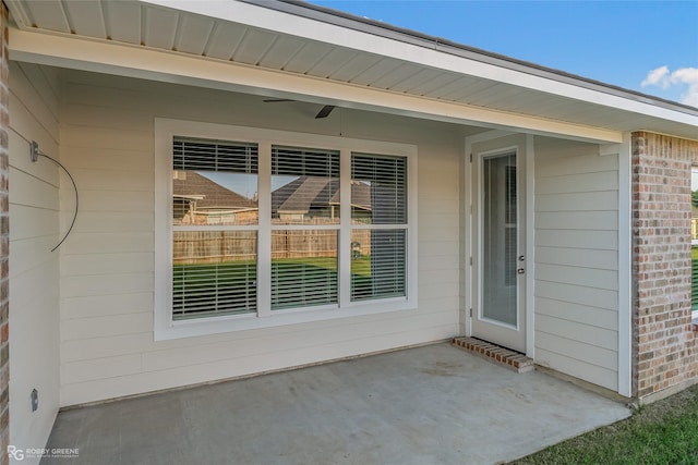 entrance to property with brick siding and a patio