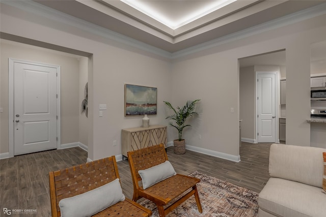 sitting room featuring ornamental molding, dark wood finished floors, and baseboards