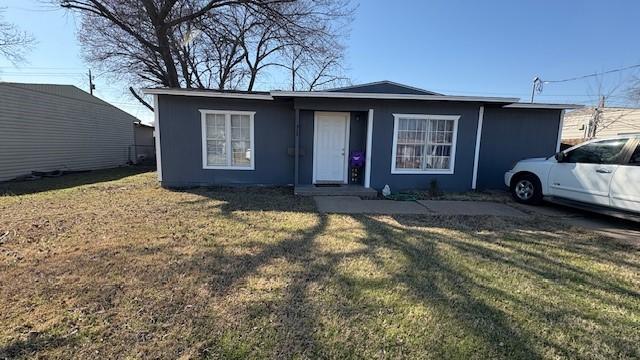 view of front facade with a front yard and stucco siding