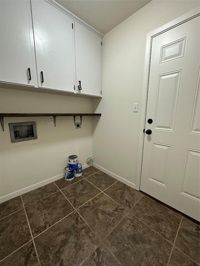 laundry area featuring dark tile patterned floors, washer hookup, baseboards, cabinet space, and electric dryer hookup