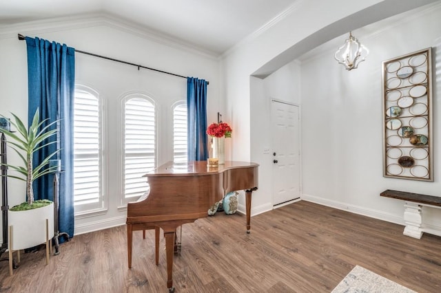 foyer entrance featuring plenty of natural light, a notable chandelier, ornamental molding, and wood finished floors