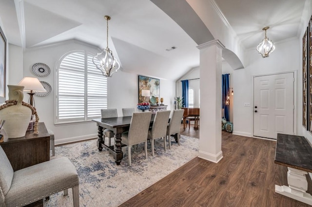 dining room with ornate columns, wood finished floors, lofted ceiling, and a notable chandelier