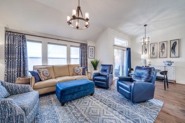 living room with baseboards, crown molding, a chandelier, and wood finished floors