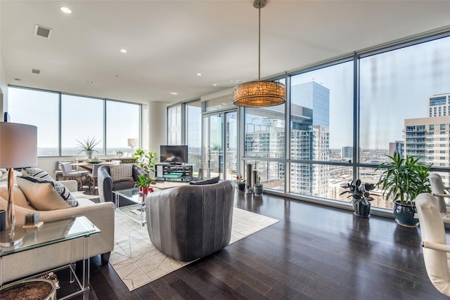 living area with expansive windows, visible vents, recessed lighting, and wood finished floors