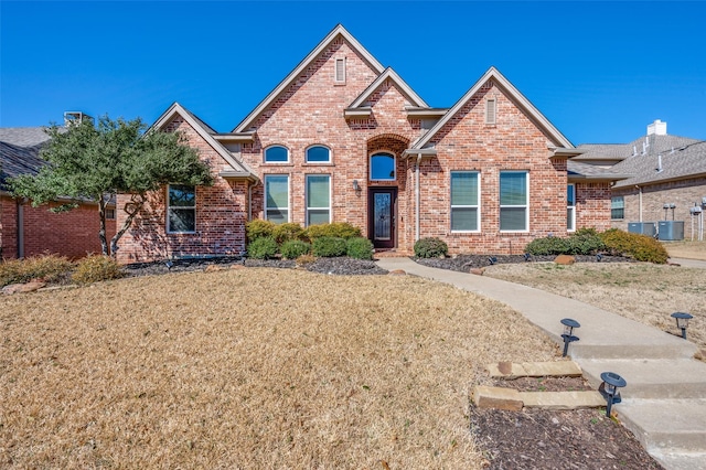 view of front facade with brick siding and a front yard