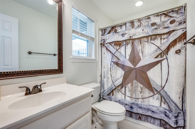 bathroom with curtained shower, toilet, and vanity