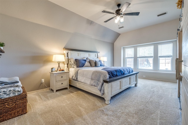 bedroom with visible vents, lofted ceiling, and light colored carpet