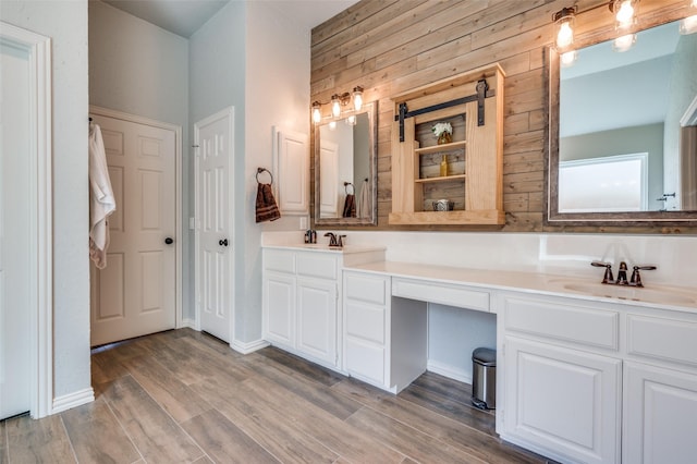 bathroom with double vanity, wood finished floors, and a sink