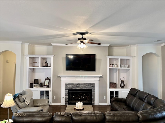 living area featuring ceiling fan, a fireplace, dark wood-style flooring, and ornamental molding