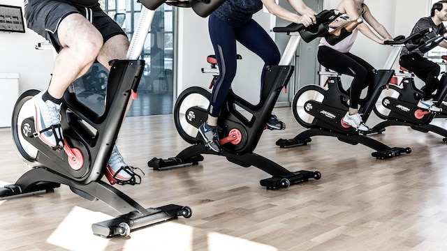 gym featuring light wood-type flooring and floor to ceiling windows