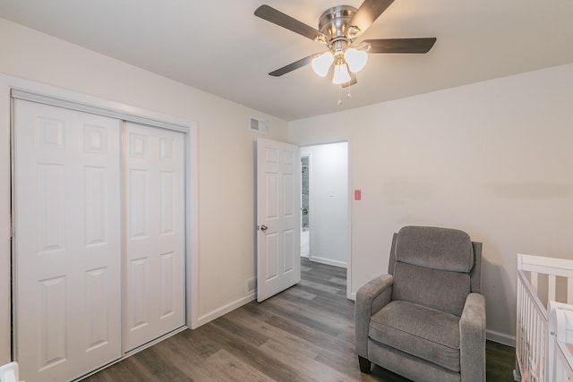 sitting room with a ceiling fan, wood finished floors, visible vents, and baseboards