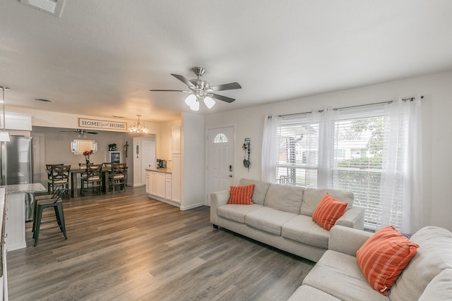 living room featuring visible vents, dark wood finished floors, and a ceiling fan