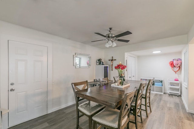 dining area with ceiling fan, dark wood-style flooring, and baseboards