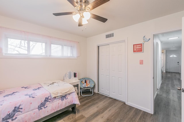 bedroom featuring a ceiling fan, visible vents, baseboards, a closet, and dark wood-style floors