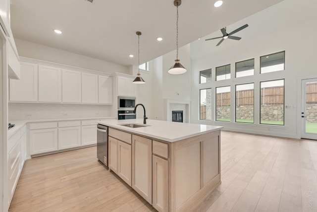 3206 Bexar St, Rockwall, TX 75032 - kitchen featuring appliances with stainless steel finishes, a glass covered fireplace, ceiling fan, recessed lighting, and a high ceiling
