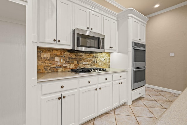 kitchen with white cabinets, decorative backsplash, stainless steel appliances, crown molding, and light countertops